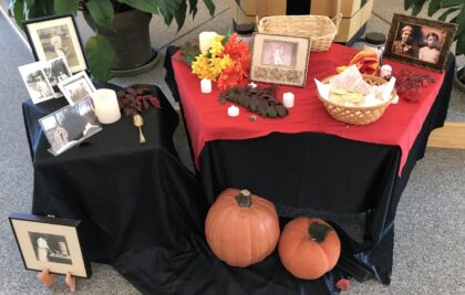 Samhain altar from 2018 including photos of deceased, candles, and fall decor