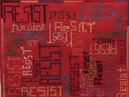 Fabric with the word "resist" embroidered on it throughout